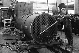 [View of boiler with holes being drilled]